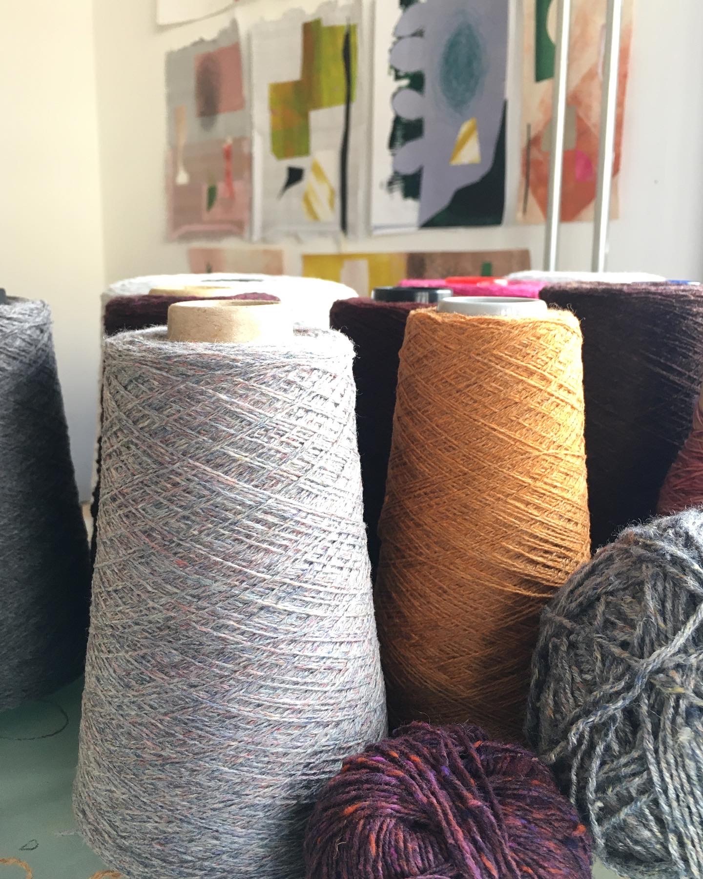 Yarns and mixed media collages in background