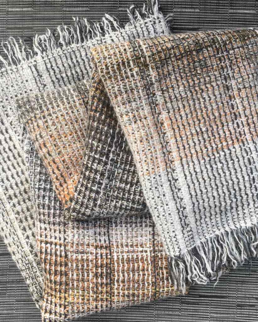 Handwoven throw folded on textured background