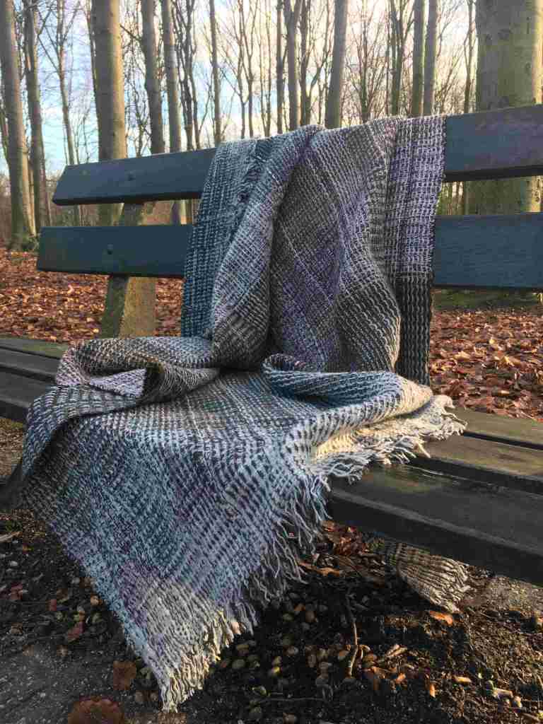 Throw on bench with trees in background