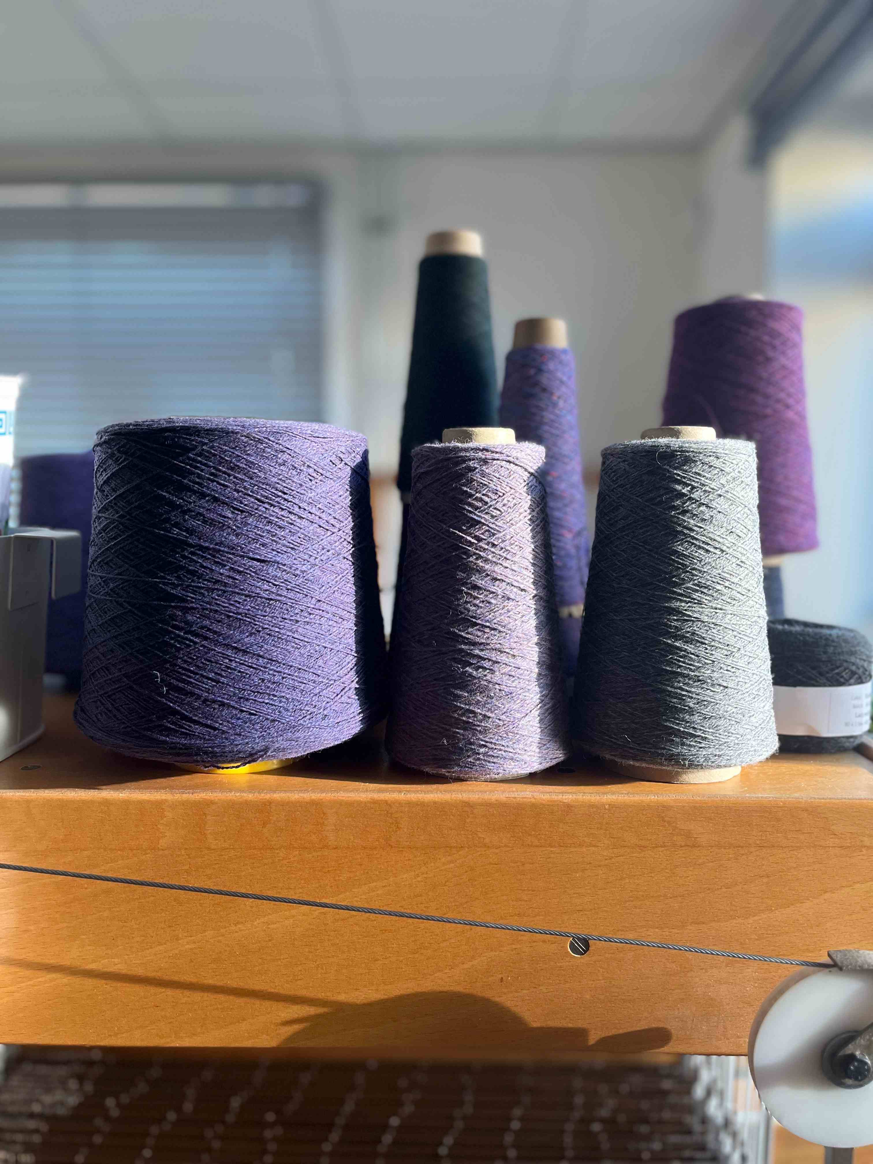 Purple yarns on top of loom