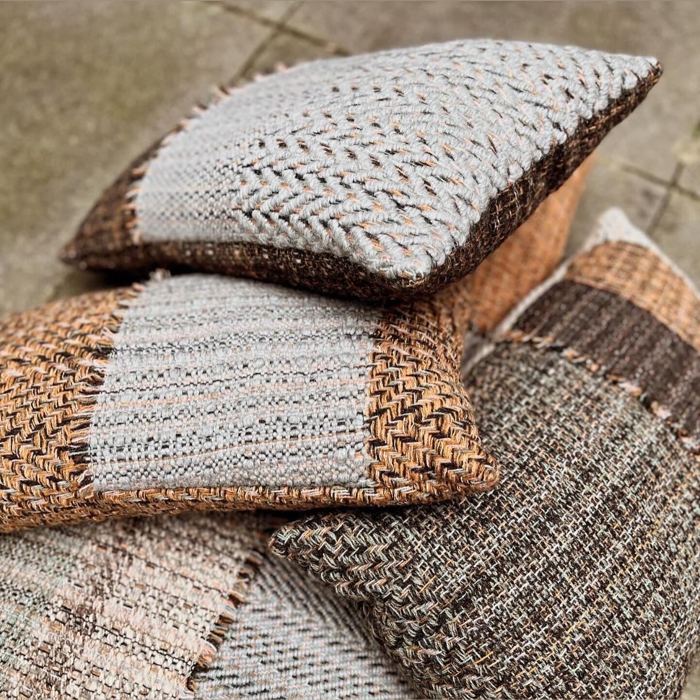 Handwoven wool cushions in earthy tones and handspun yarns, filled with recycled polyester